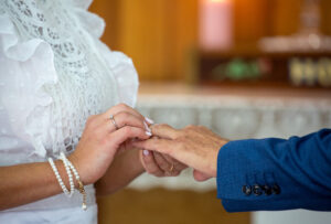 Bride placing wedding ring